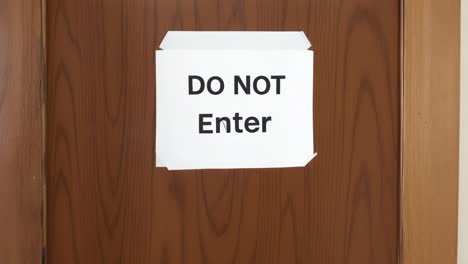 a "do not enter" sign taped to a wooden door