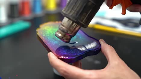 a creative process unfolds: applying heat to colorful resin art for a stunning visual transformation and unique textures in artistic craftsmanship