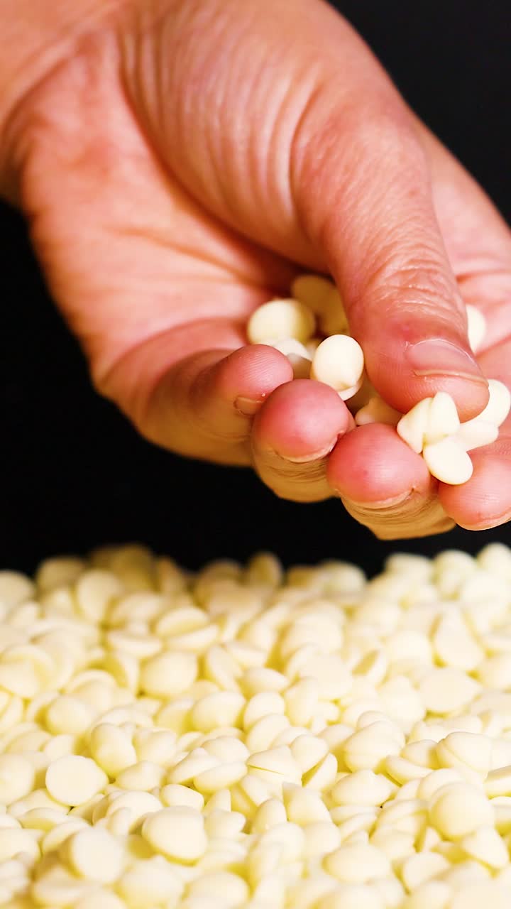 recogiendo a mano trozos de chocolate blanco de la pila