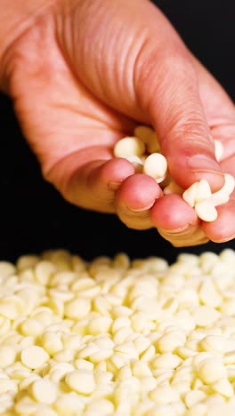 recogiendo a mano trozos de chocolate blanco de la pila