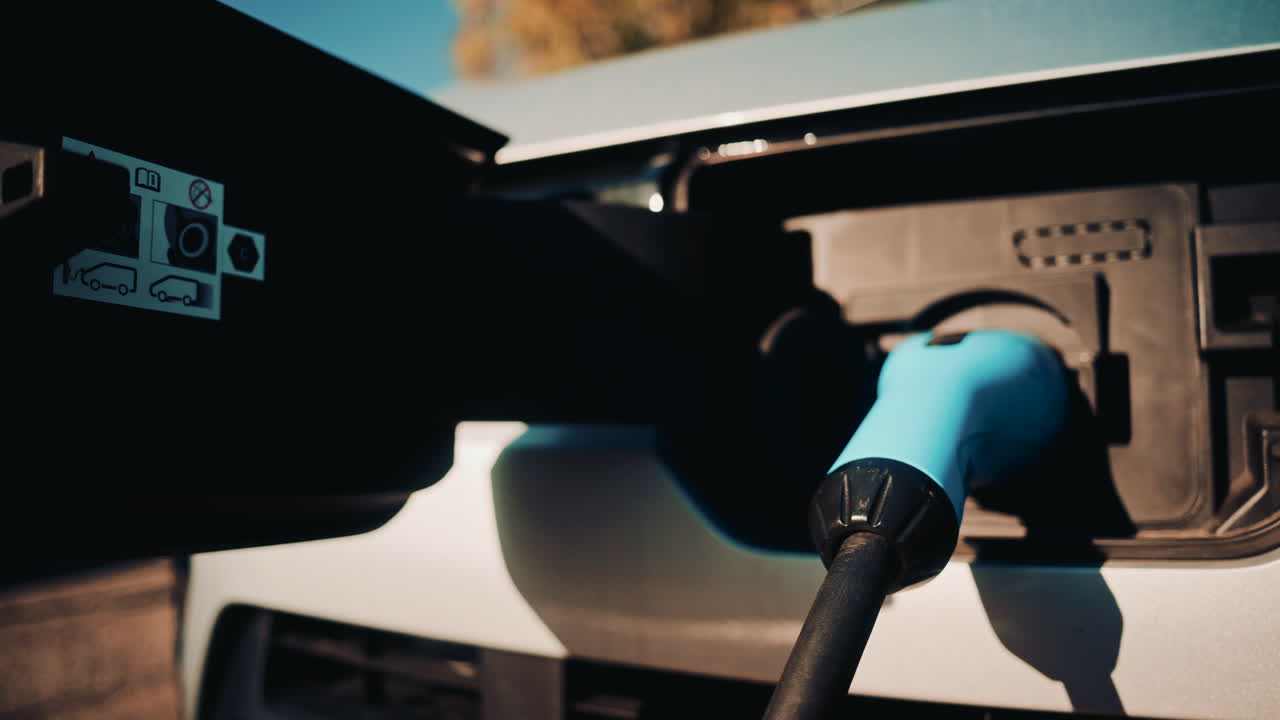 Close up shot of an electric vehicle charging port with cable connected