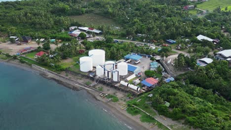 fotografía aérea de una instalación costera de almacenamiento de combustible rodeada de un exuberante pueblo tropical en catanduanes, filipinas