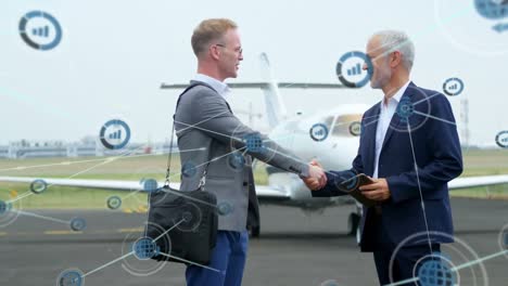 animation of network of digital icons over two caucasian businessmen shaking hands at the airport