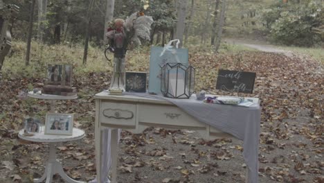 white-wooden-table-in-vintage-style-decorated-with-lamps-and-inscription-of-the-names-of-the-brides,-bouquet-of-flowers-on-the-table-at-the-wedding-ceremony-venue,-garden-party-wedding