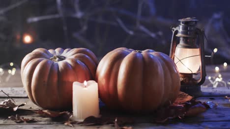 Video-of-halloween-pumpkins-and-candle-with-copy-space-on-wooden-background