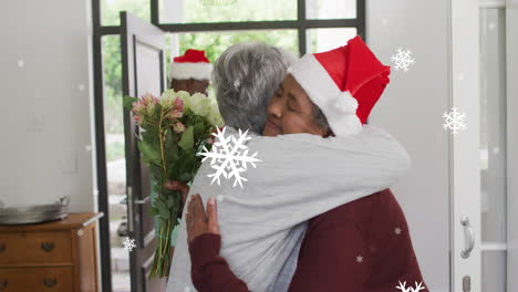 animación de copos de nieve blancos de navidad sobre diversas amigas mayores abrazándose en la puerta