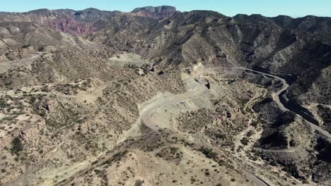 Serpentine-highway-twists-around-rugged-mountain-landscape,-Argentina