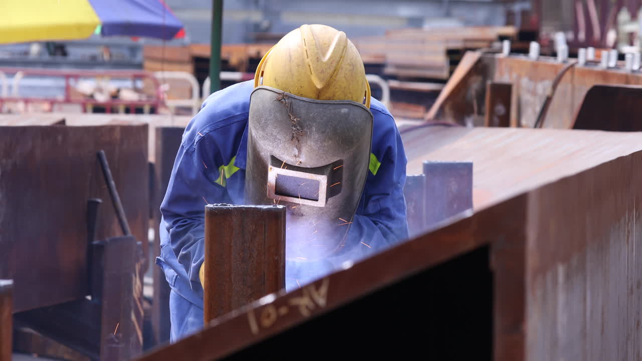 Trabalhador com máscara de solda enquanto fabrica aço enferrujado ao ar livre.