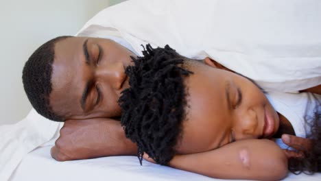 familia negra durmiendo bajo una manta en el dormitorio en casa 4k