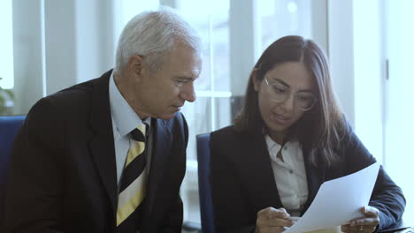 mujer profesional con traje y gafas que explica el documento