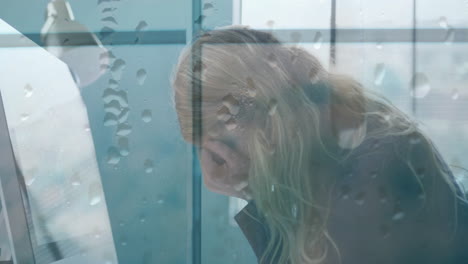 animación de gotas de agua sobre angustiada mujer de negocios caucásica con la cabeza en las manos