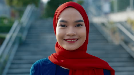 close-up portrait of a young woman in a red hijab outdoors