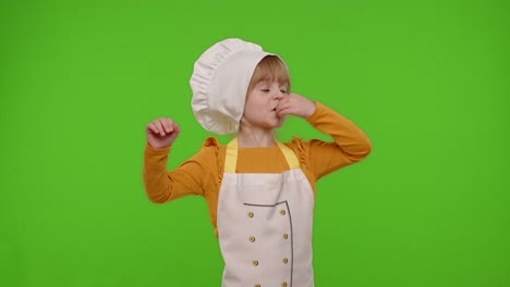 Niña-Vestida-Con-Delantal-Y-Sombrero-Como-Chef,-Cocinero,-Panadero,-Levantando-Las-Manos,-Mostrando-Un-Gesto-Sabroso