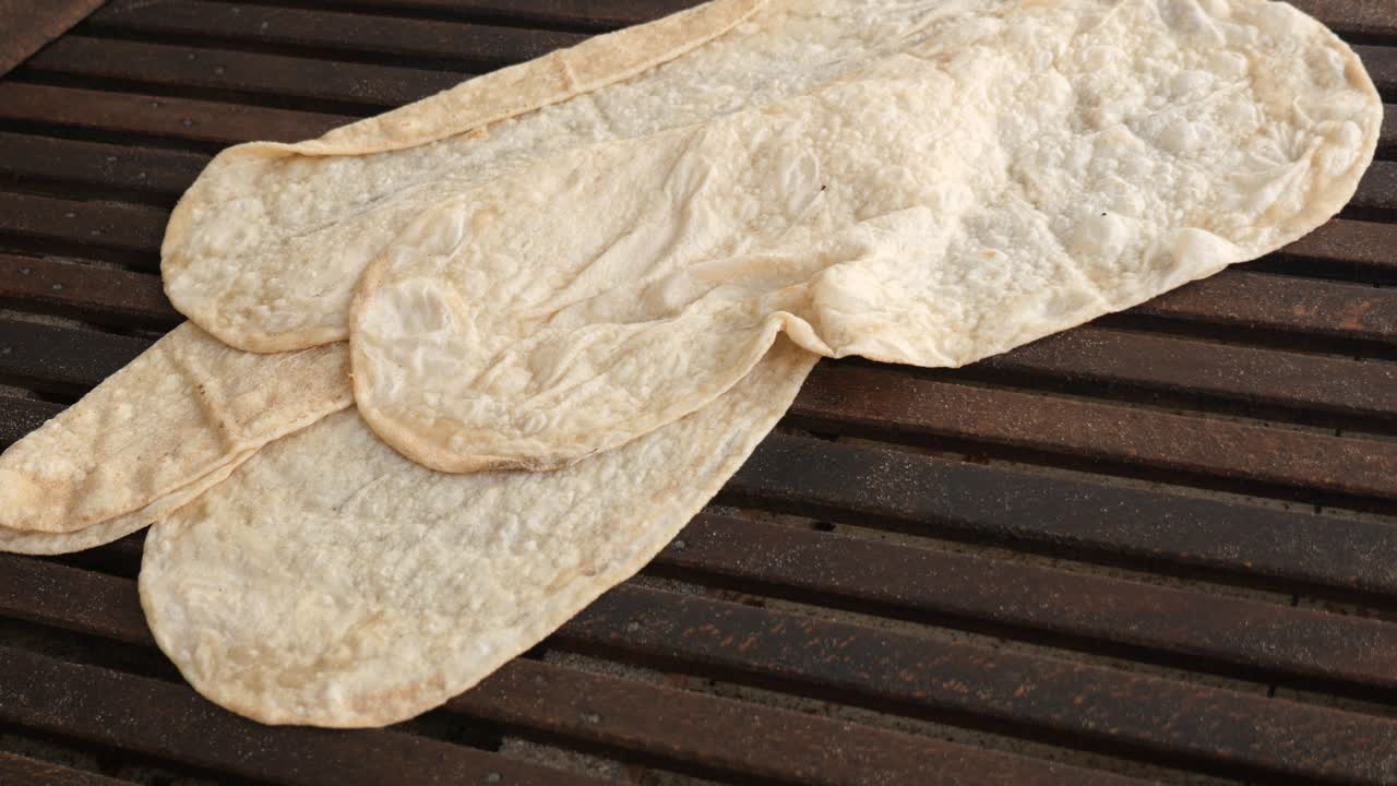 Hand preparing homemade flatbread on a wooden surface