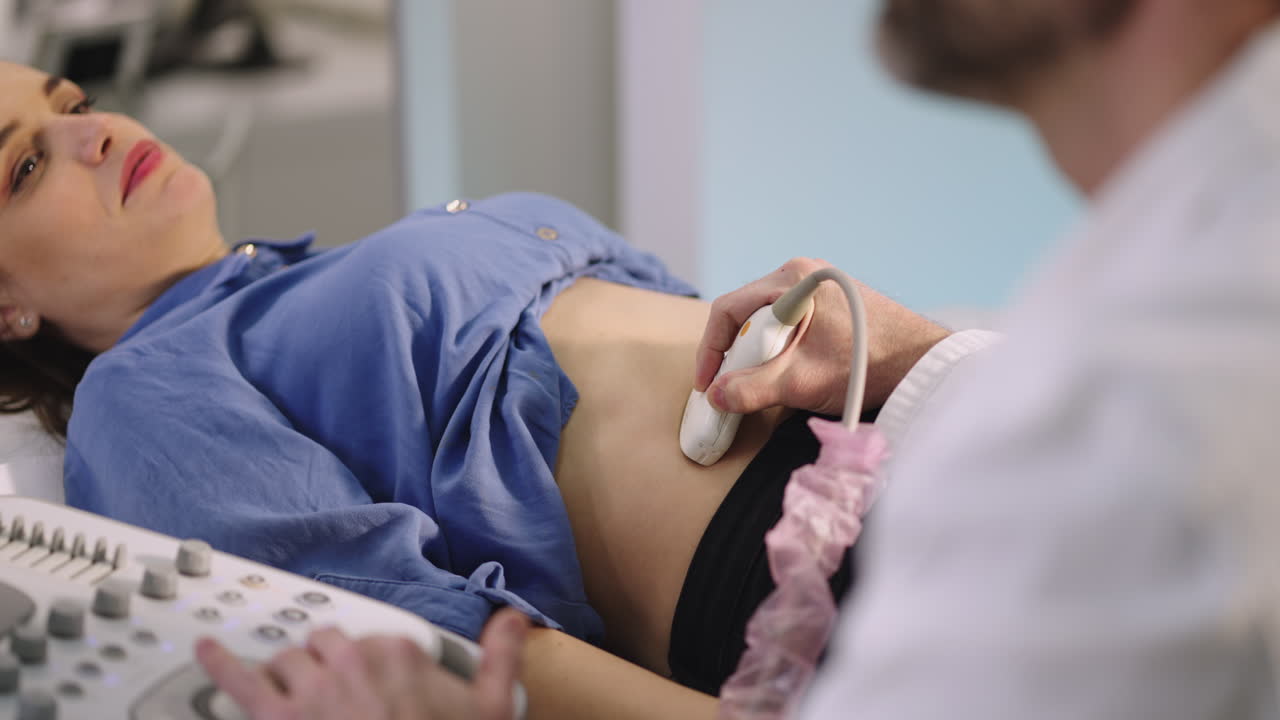 Woman receiving an abdominal ultrasound from a doctor