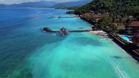 beach fromt of candidasa in bali showing the clear blue water and wave breakers to stop erosion of the beaches