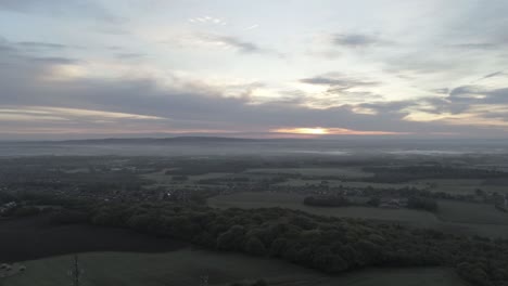early sunrise aerial telecom towers on agricultural rural farmland countryside slow drift left