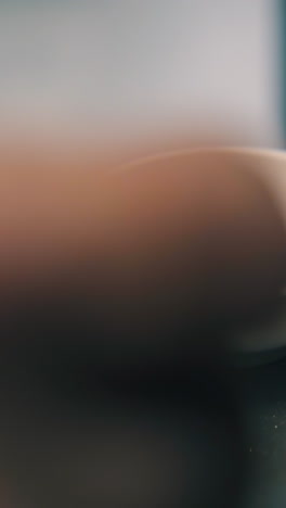 cu: jeweler puts beautiful white gold chain into porcelain bowl on scale against blurred background in workshop closeup