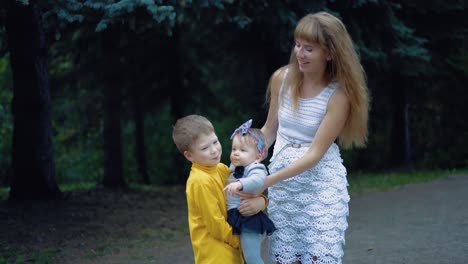 young mother and her two sons play with the baby