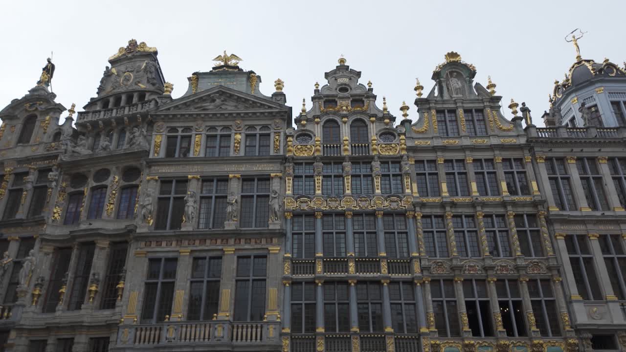 Low angle view of historical buildings facades with ornate decoration and golden statues in Grand Place, Brussels