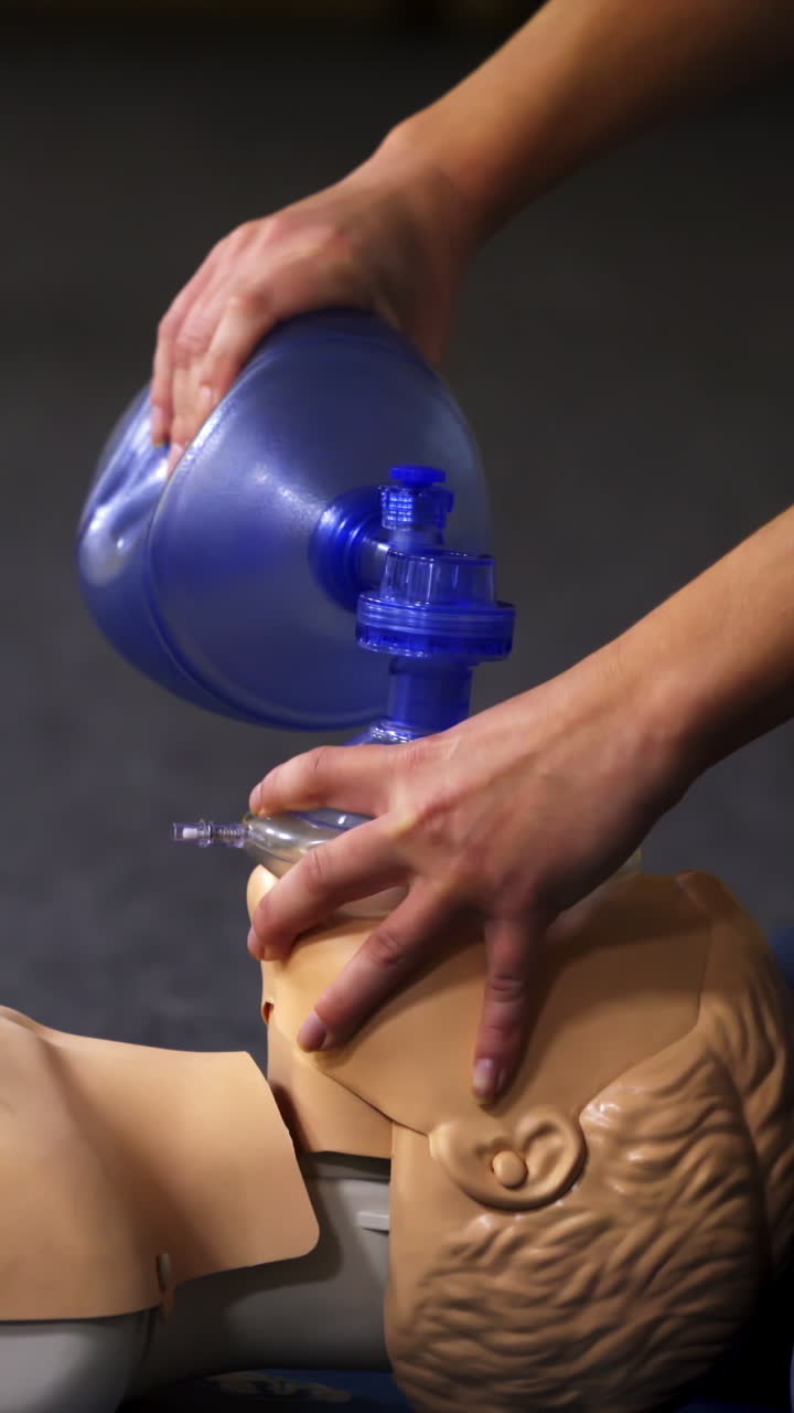 Teaching procedure on a dummy. Medical demonstration of resuscitation on a mannequin in training center. Instructor showing breathing exercise with medical apparatus. Vertical video