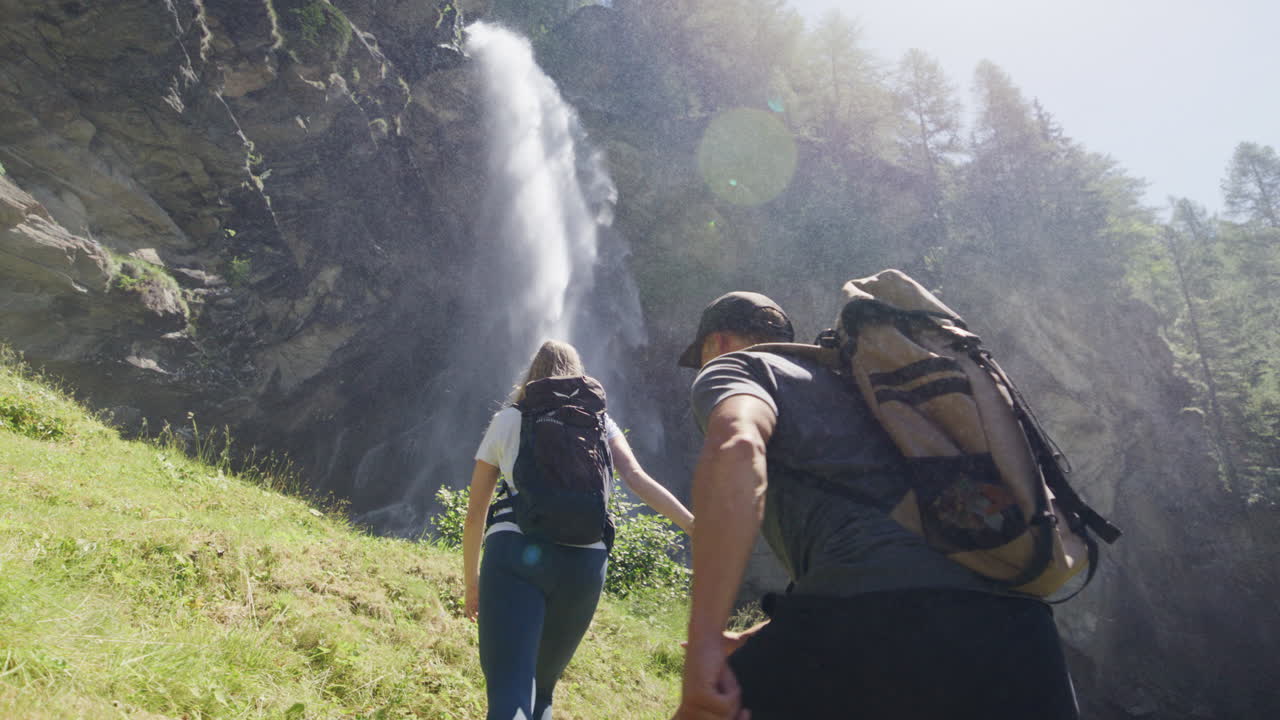 Two hikers explore Saas-Fee, Saas-Balen, and the Saas-Almagell dam, passing waterfalls, marmots, and alpine peaks in a breathtaking high-mountain landscape.