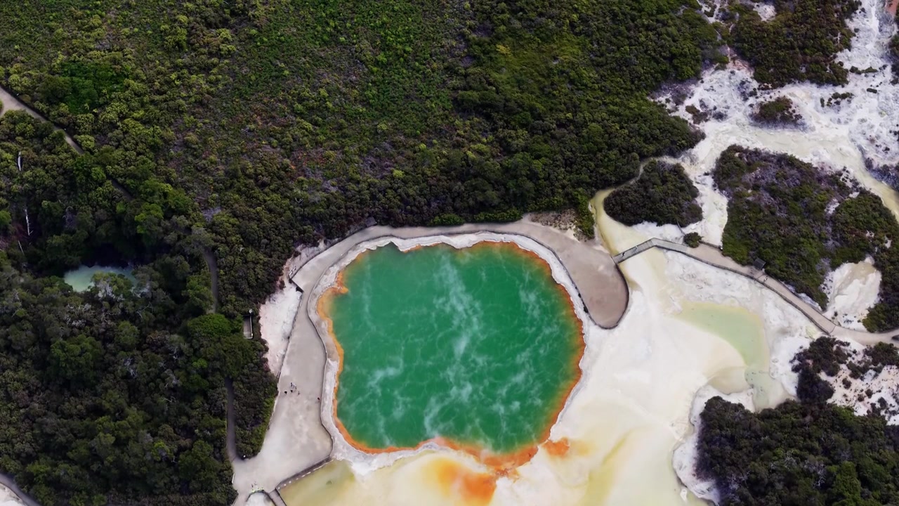 Champagne Pool di Wai-O-Tapu, Rotorua, Selandia Baru, air panas bumi hijau cerah, endapan mineral oranye, dan medan vulkanik, pemandangan udara
