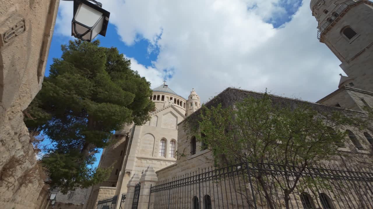 Picturesque hyperlapse view of the Dormition Abbey's dome and tower, framed by trees in Jerusalem