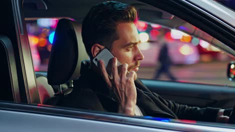 man talking on phone while driving at night