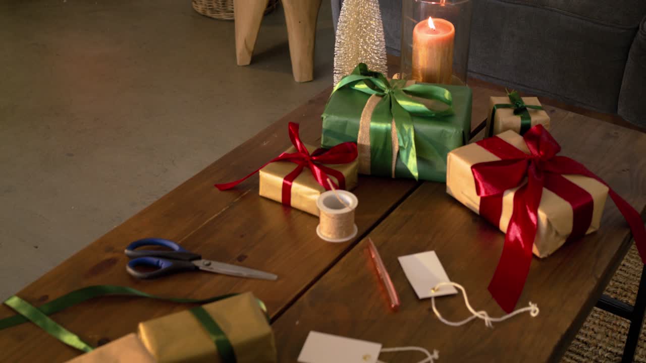 Camera is panning and zooming from stove toward coffee table focusing on ribbons and gift tags