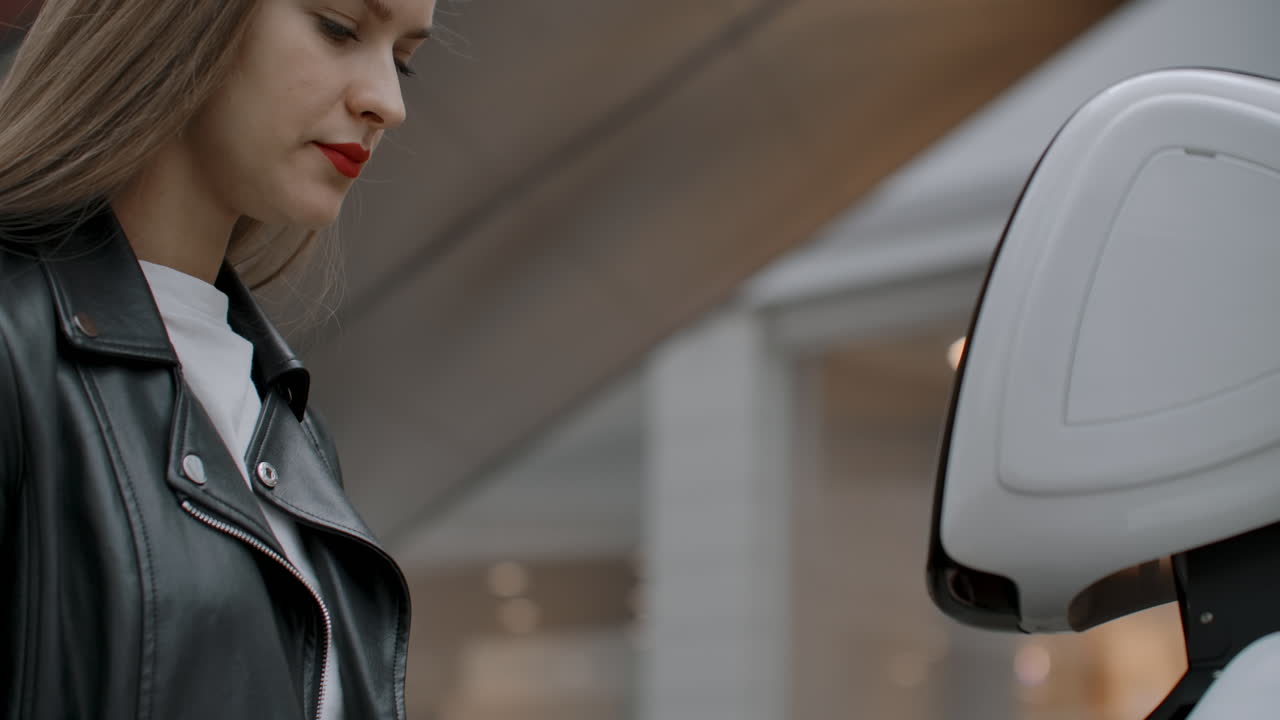 una chica sonriente con una camiseta blanca está en contacto con un humanoide. cyborg ayuda a la chica a responder preguntas. asistente robótico útil en la oficina y en el centro comercial