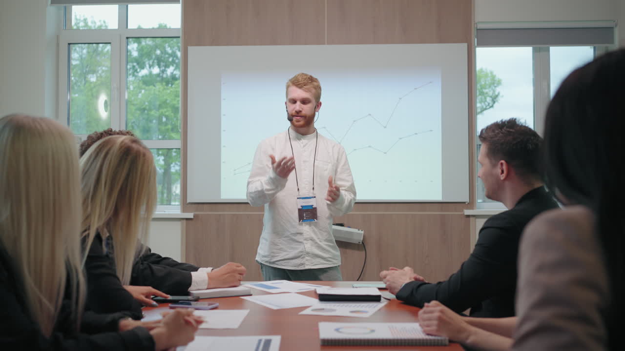 투자 및 금융에 관한 교육 컨퍼런스 남성 전문가가 참가자 앞에서 연설하고 있습니다.