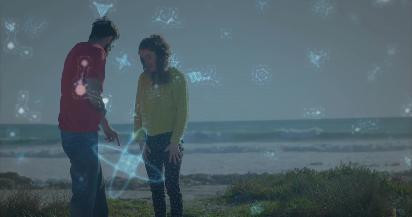 Uomo che gesticola e donna che esamina il bordo della spiaggia, mostrando grafici di rete della tecnologia di realtà aumentata