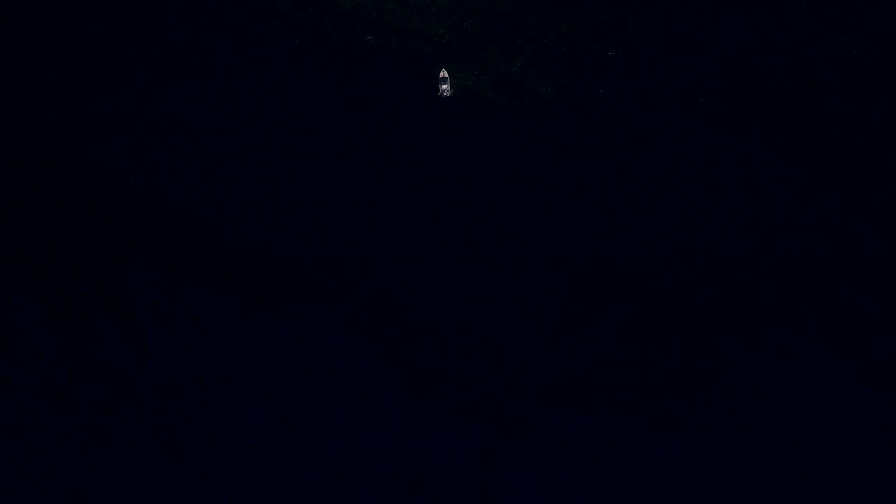 disparo de avión no tripulado que revela un barco de pesca en el oscuro océano vasto