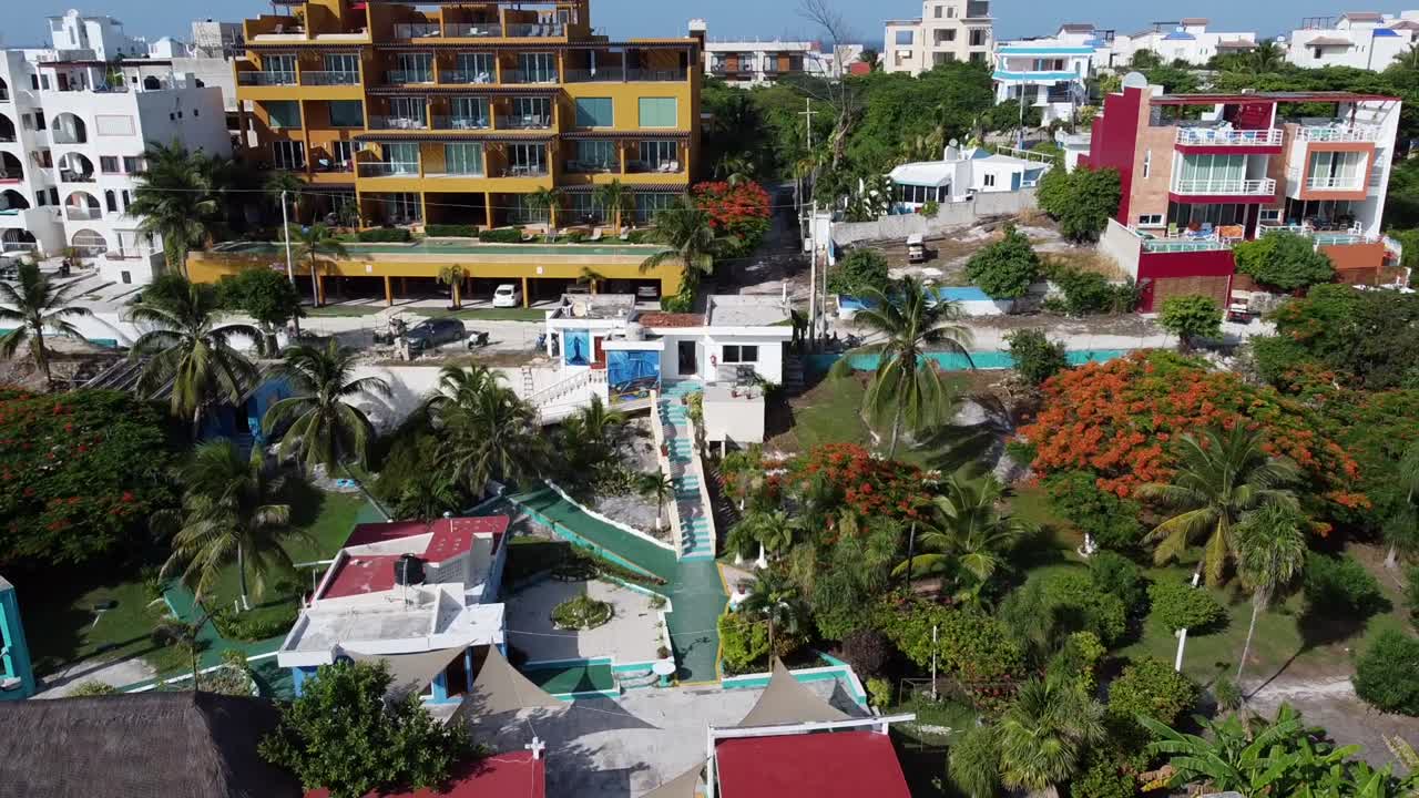 una toma alejada de hermosas casas coloridas y un hotel junto a una maravillosa playa en isla mujeres en méxico