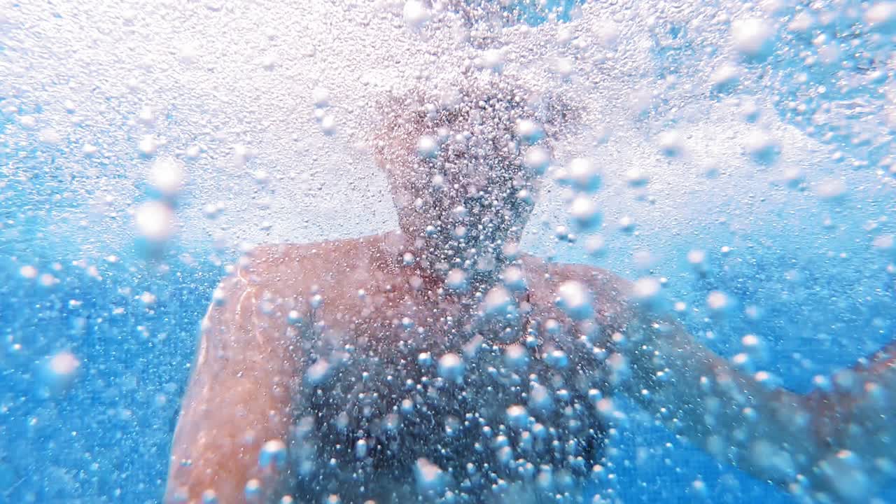 Man swimming in pool. Handsome man swimming underwater in pool
