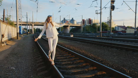 young woman having fun walks by rail to rail laughing steadicam shot