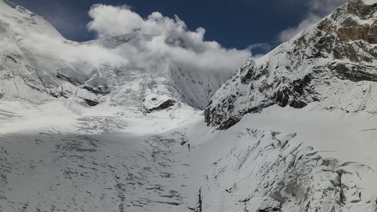 A breathtaking drone angle displays glacier-carved terrain leading toward Mount Everest, surrounded by towering Himalayan formations