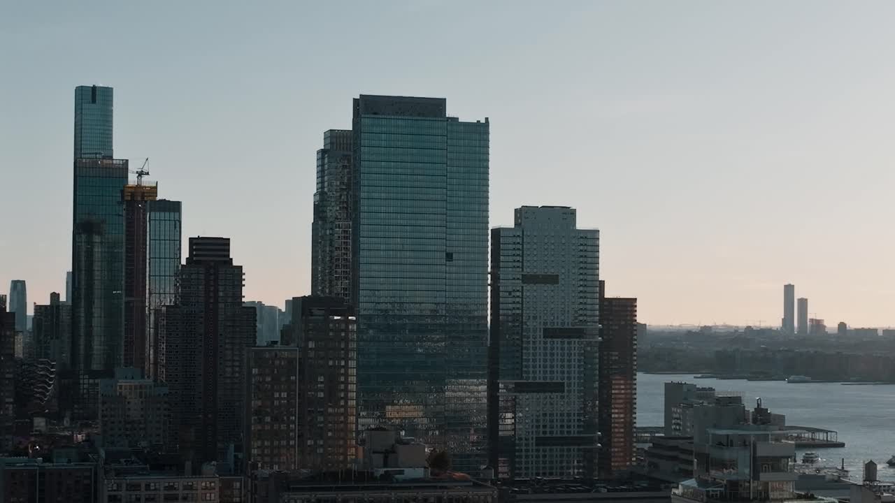 Høye bygninger i New York City langs elven ved solnedgang
