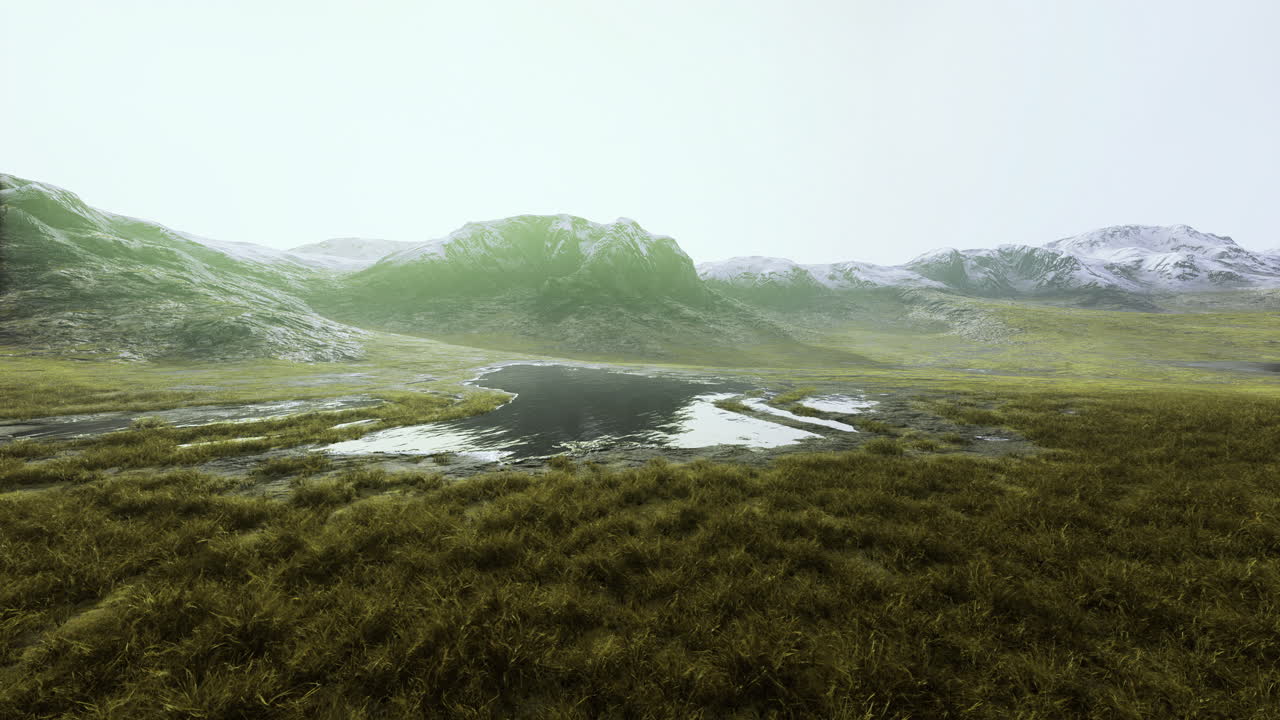 Vast green landscape with a shimmering body of water in a mountainous region