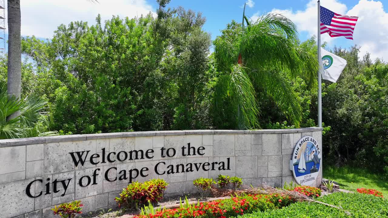 Welcome to Cape Canaveral Sign with American Flag and Tropical Scenery
