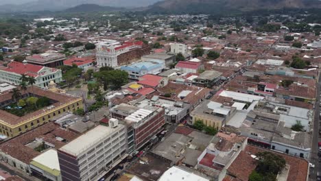 Low-aerial-orbits-Santa-Ana-Cathedral-and-El-Salvador-city-skyline