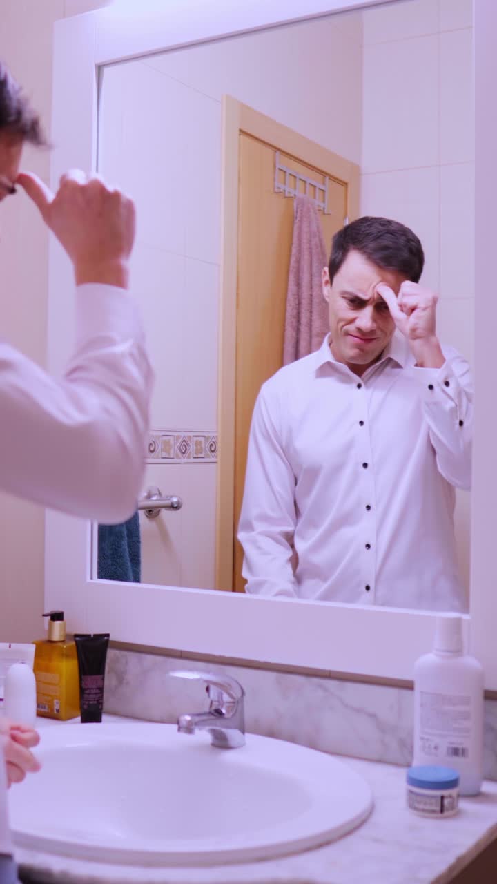 Nervous businessman rehearsing speech in bathroom mirror
