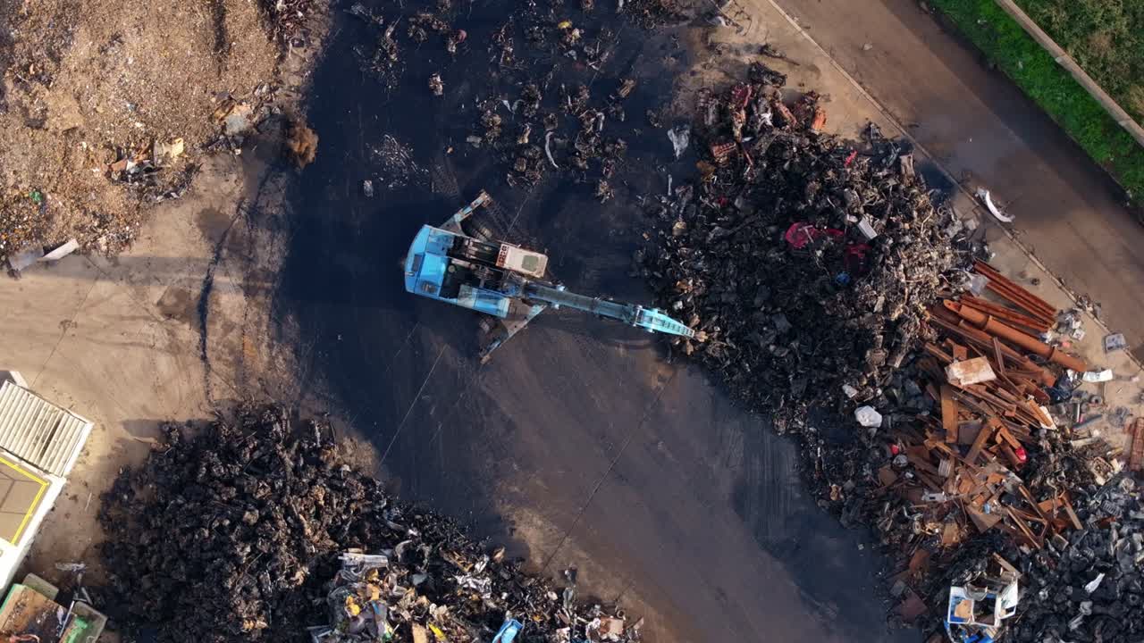 Ripresa da drone di un deposito di rottami con imponenti cumuli di metallo e una gru in funzione