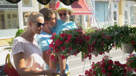 parents and son looking at flowers in the street