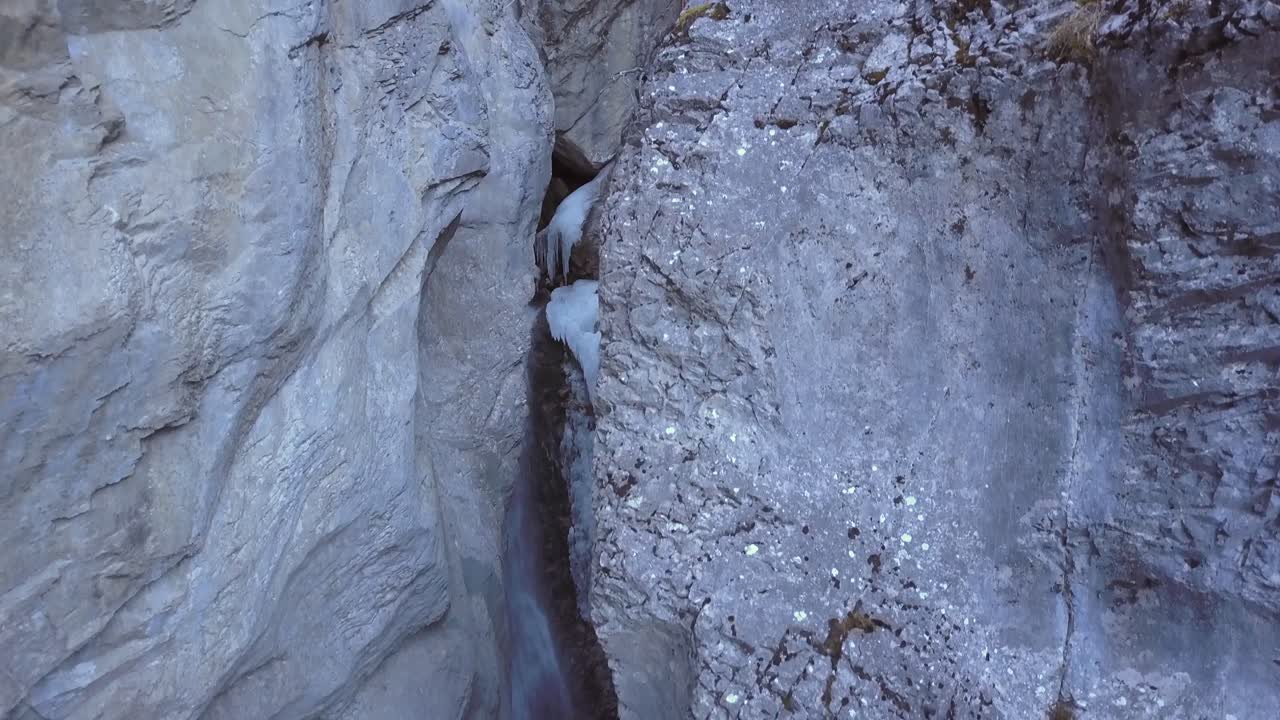 disparo de grúa aérea desciende en el cañón de cascada vertical helada, invierno