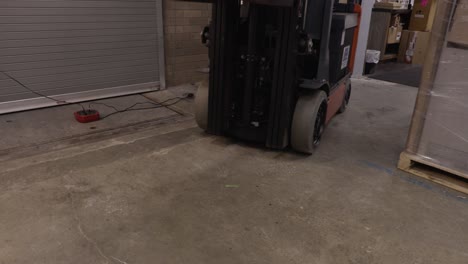 front view of an electric fork lift raising and lowering pallet and boxes