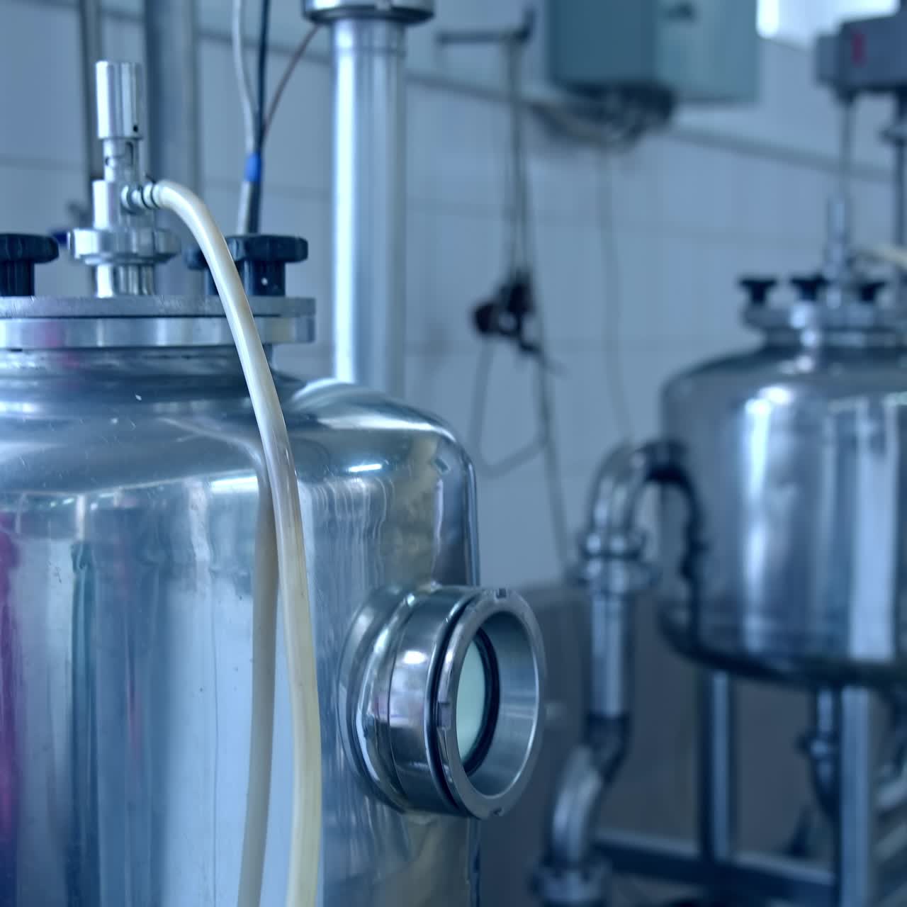 Contemporary equipment on a milk farm indoors. Stainless containers for keeping and processing dairy products on a milk factory