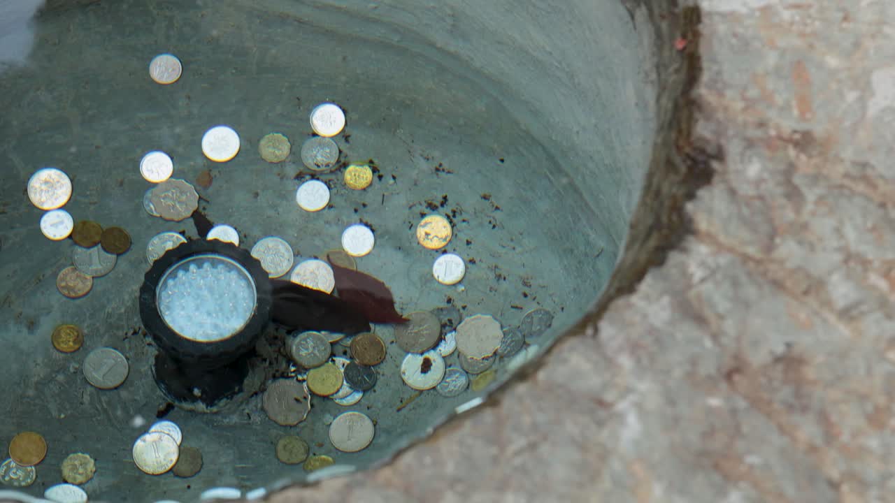 monedas esparcidas en una fuente de piedra