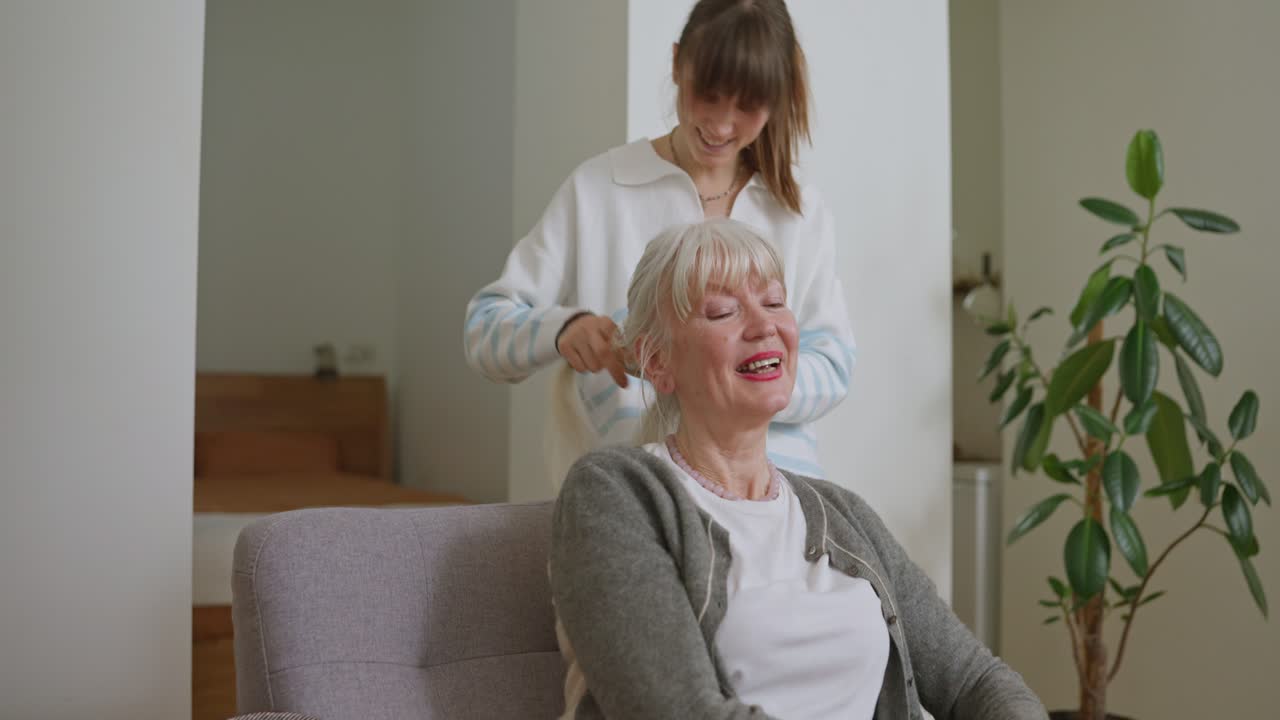 Senior woman getting her hair done by a caregiver